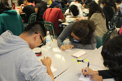 Freshman mentee Jerry Zhang (left) and sophomore mentor Grace Kim exchange contact information and class schedules at the meeting, to reference in the future when planning activities together.