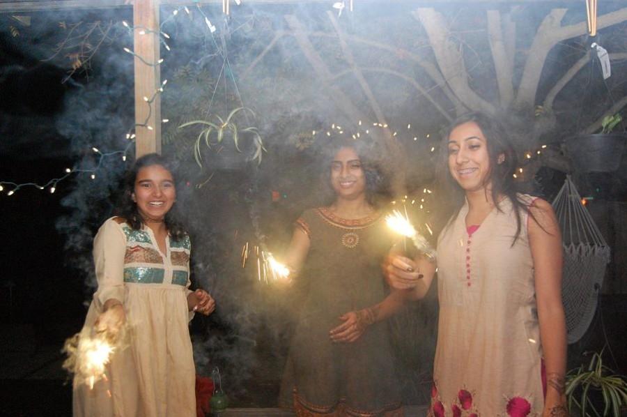 From left to right, Maryam Chenna, Savita Sastry and Koodrut Panesar celebrate Diwali with sparklers