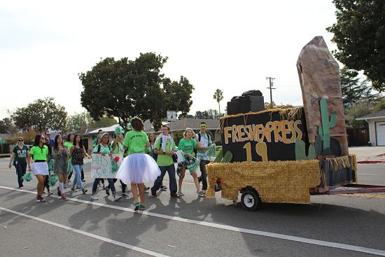 The freshman class walks with their Fresh express float