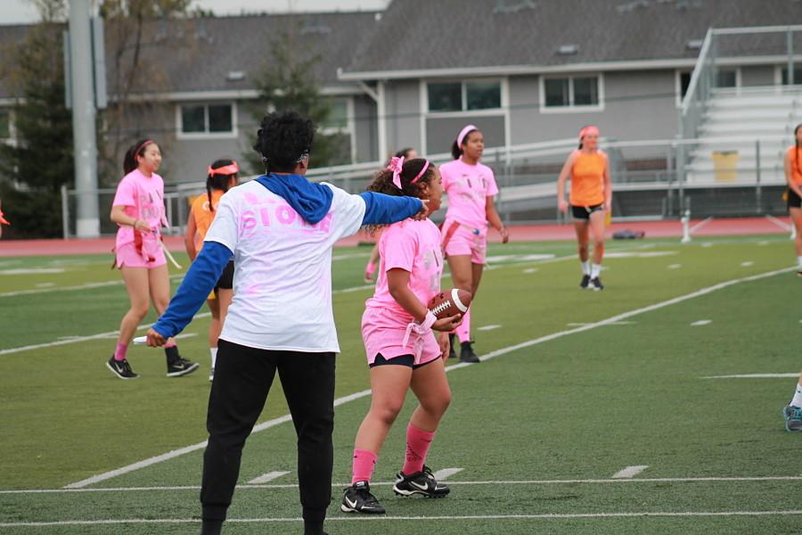 Junior Powderpuff captain Sione Moli directs junior Brooklyn Sylve during the beginning of a play.