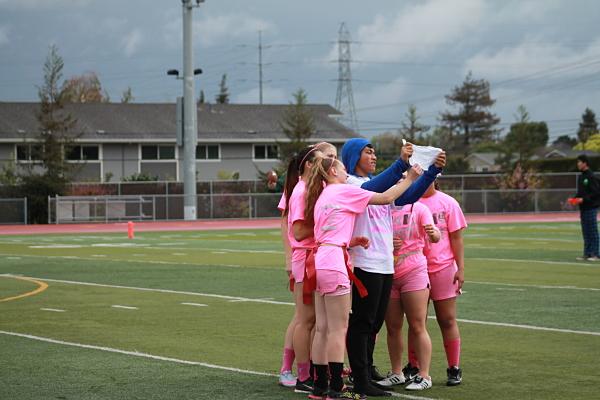 Junior Powder Puff Captain Sione Moli shows the girls on his team the play he plans to enact next.