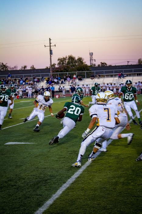 Ward rushes the ball through the Leland High School defense, Sept. 2