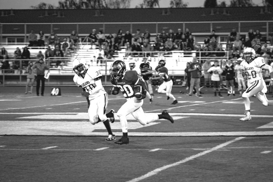 Ward rushes the ball through the Leland High School defense, Sept. 2