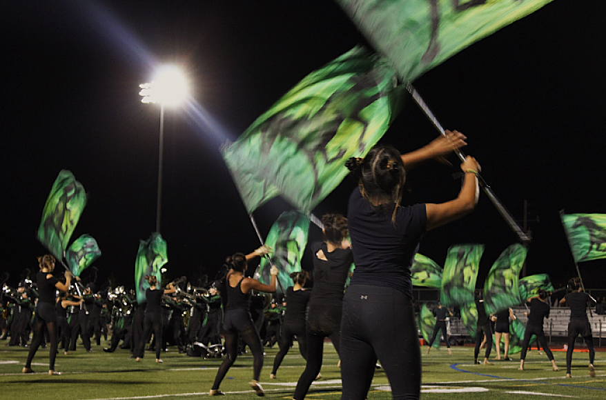 A+color+guard+member+in+the+process+of+flipping+her+flagpole