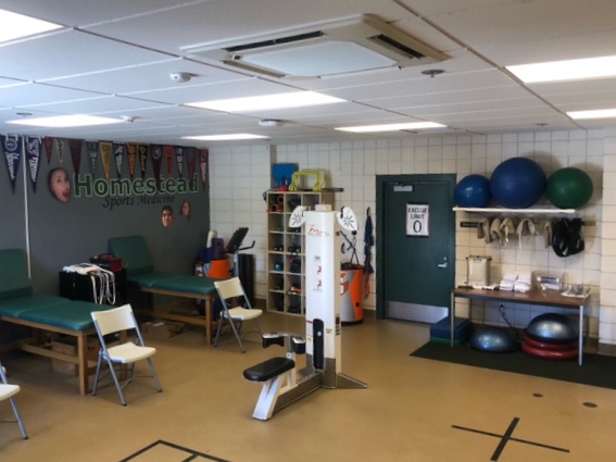 Yusim helps a student athlete in the Athletic Training room, where he encourages all students to visit with any questions they may have about injury prevention or recovery or even just general health and nutrition.