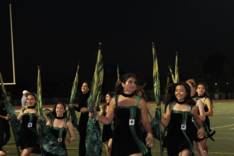 FRIDAY NIGHT LIGHTS: Colorguard runs off the field after the pregame show and keeps spirits high throughout Friday night football games