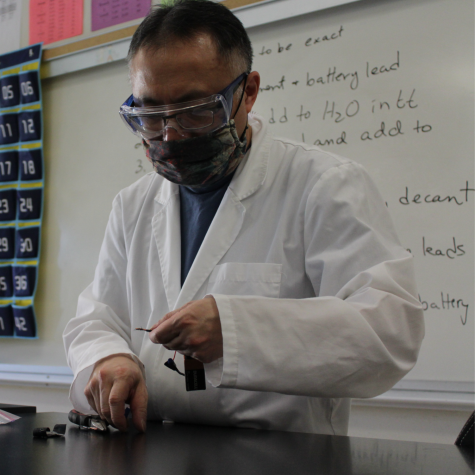 Samuel Fung works with students in his AP chemistry class on an experiment related to batteries.