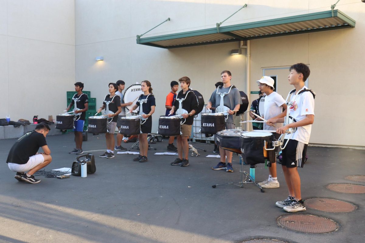  Near the football field, Jacob Jang and members of the Homestead Marching Band prep for the upcoming EXPO.