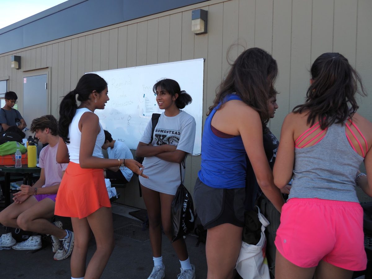 Cross country members socialize before a practice.
