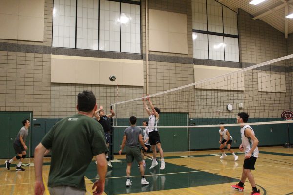 The current volleyball team prepares to block the hit from the alumni team. 2007 graduate, alumnus Ryan Dedrick and varsity captain Scott Moore both said playing against each other is rewarding skill-wise.