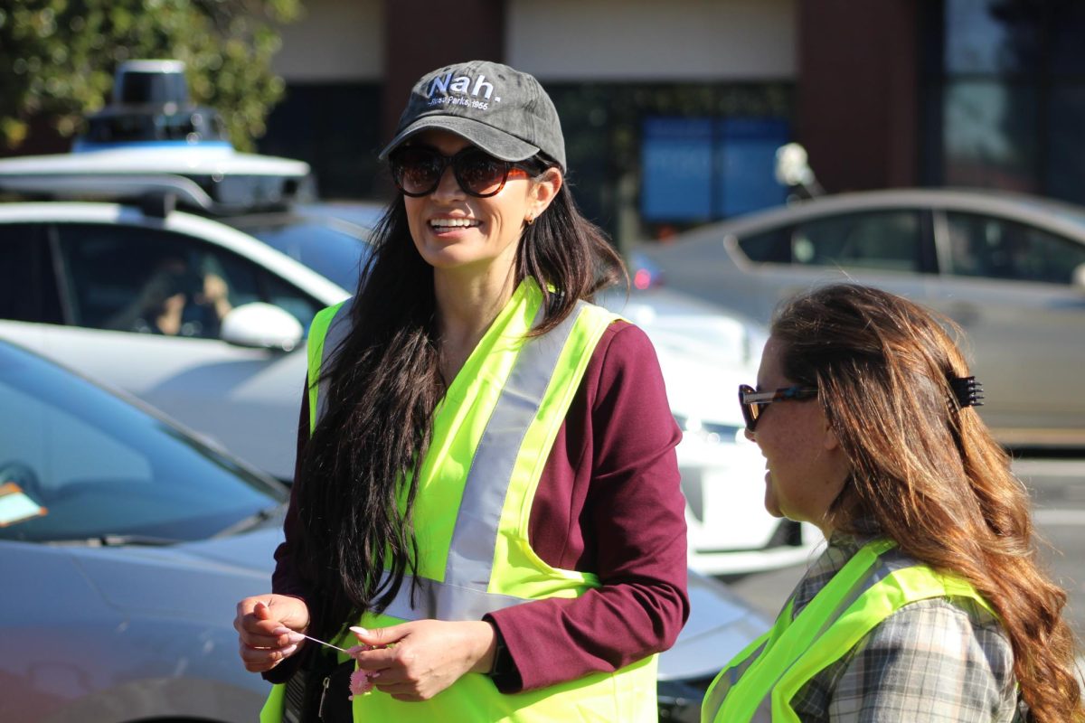 Sporting bright neon vests, administrators line the sides of the walkout group, ensuring students stay hydrated and safe on sidewalks.
